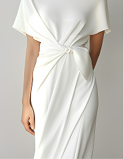 Primer plano de un vestido blanco elegante con un nudo torcido a la altura de la cintura.