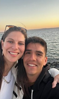 Stefy y Joaco abrazados frente al mar al atardecer